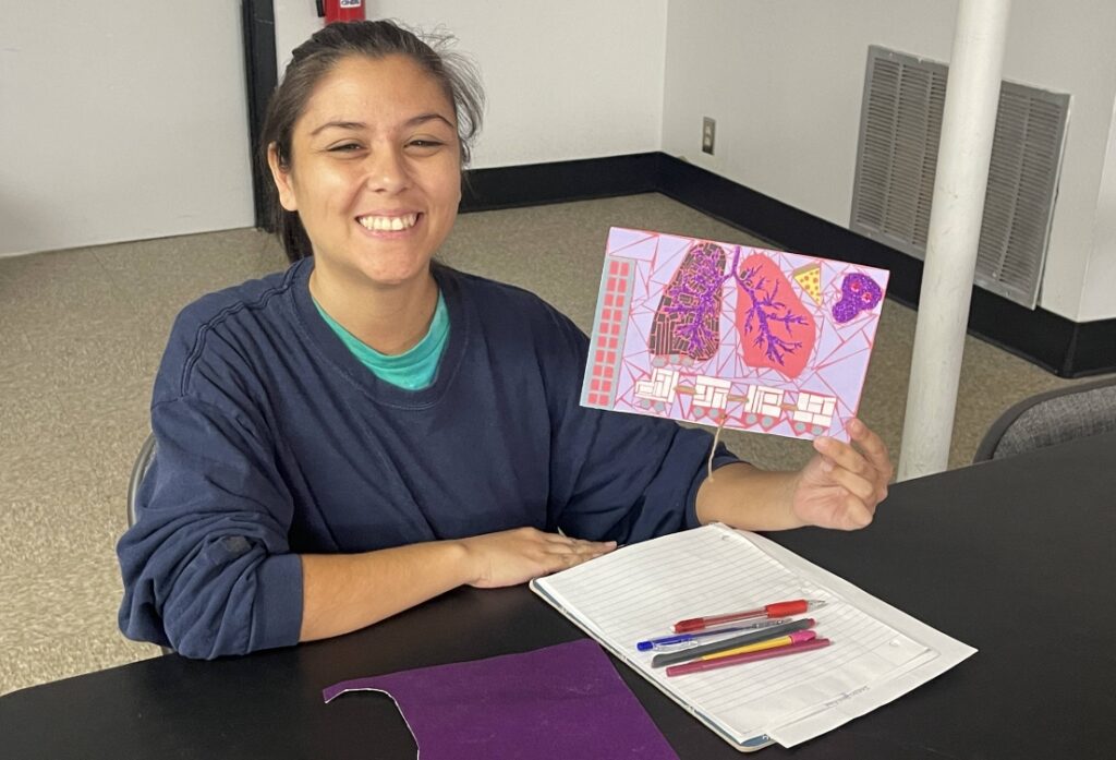 happy artist showing her work of art